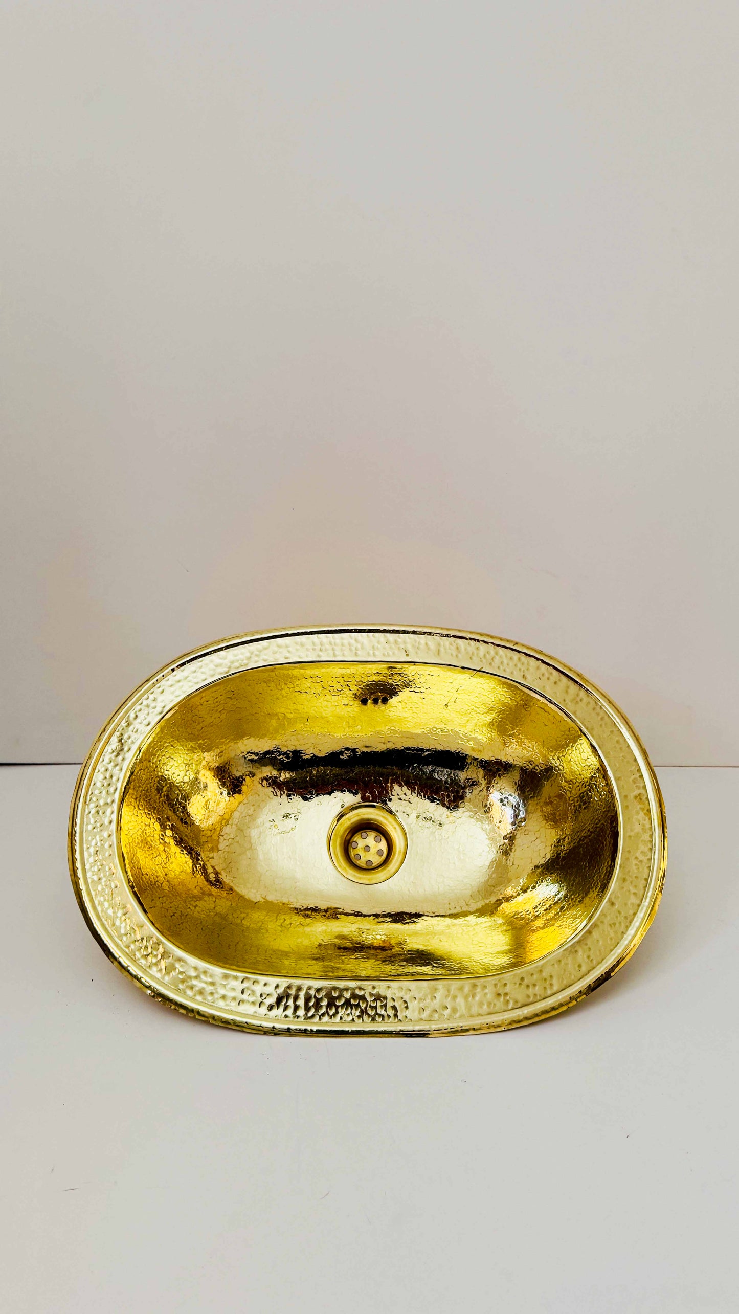 a gold sink on a white counter top
