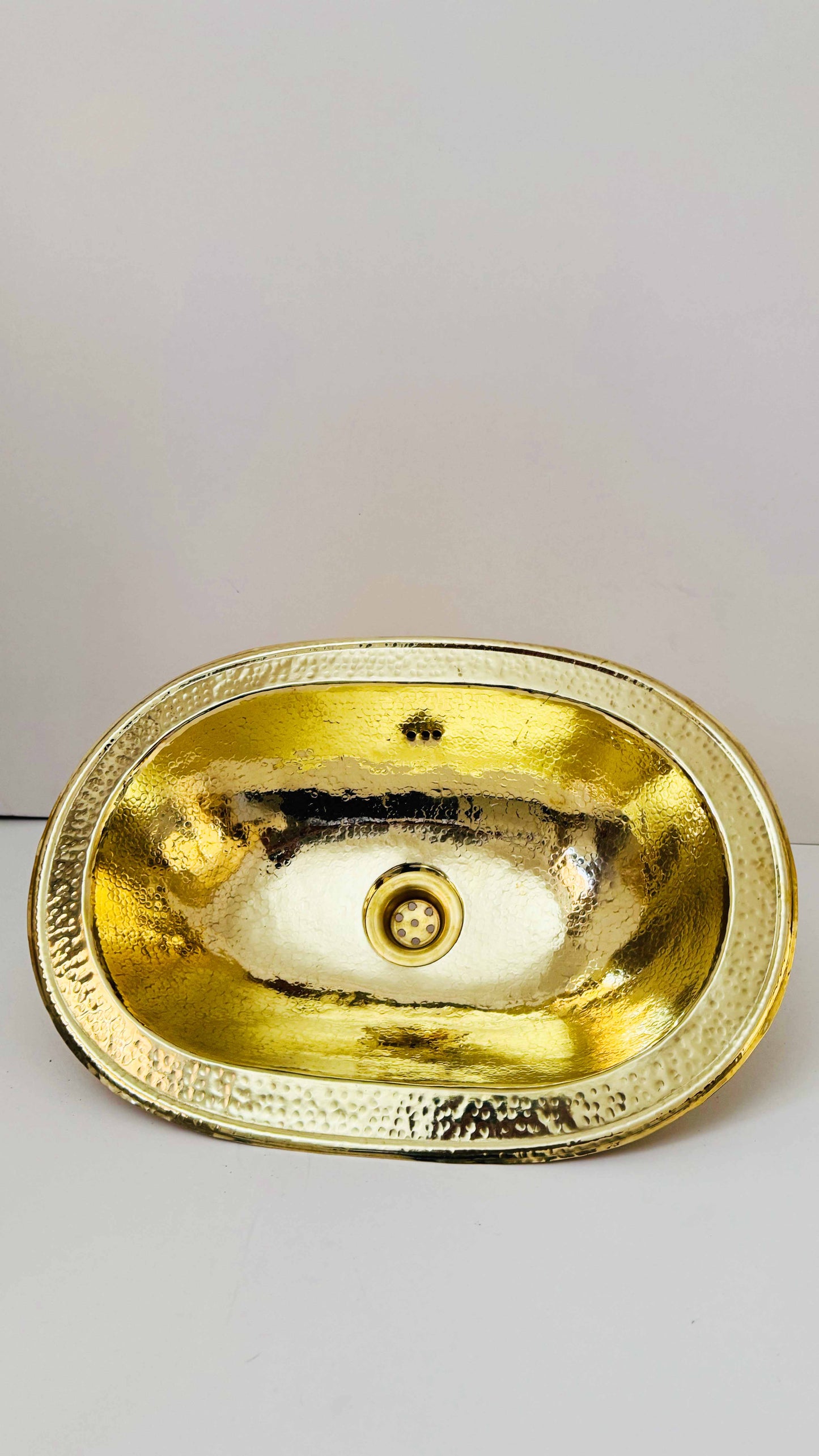 a gold oval shaped sink on a white surface
