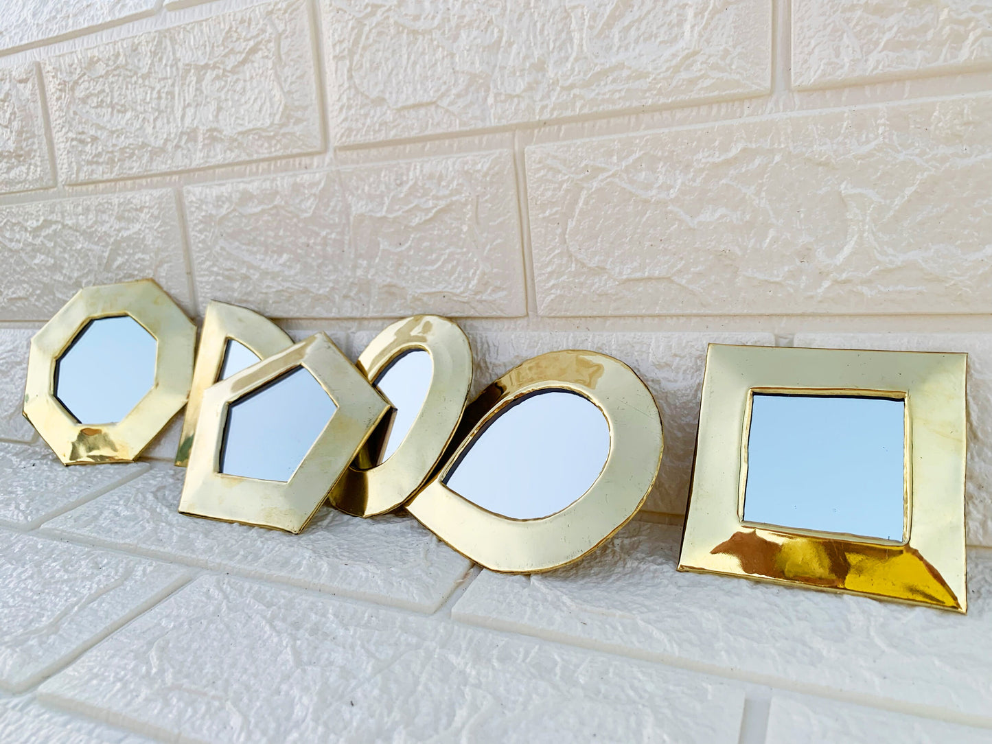 a row of three mirrors sitting on top of a tiled floor