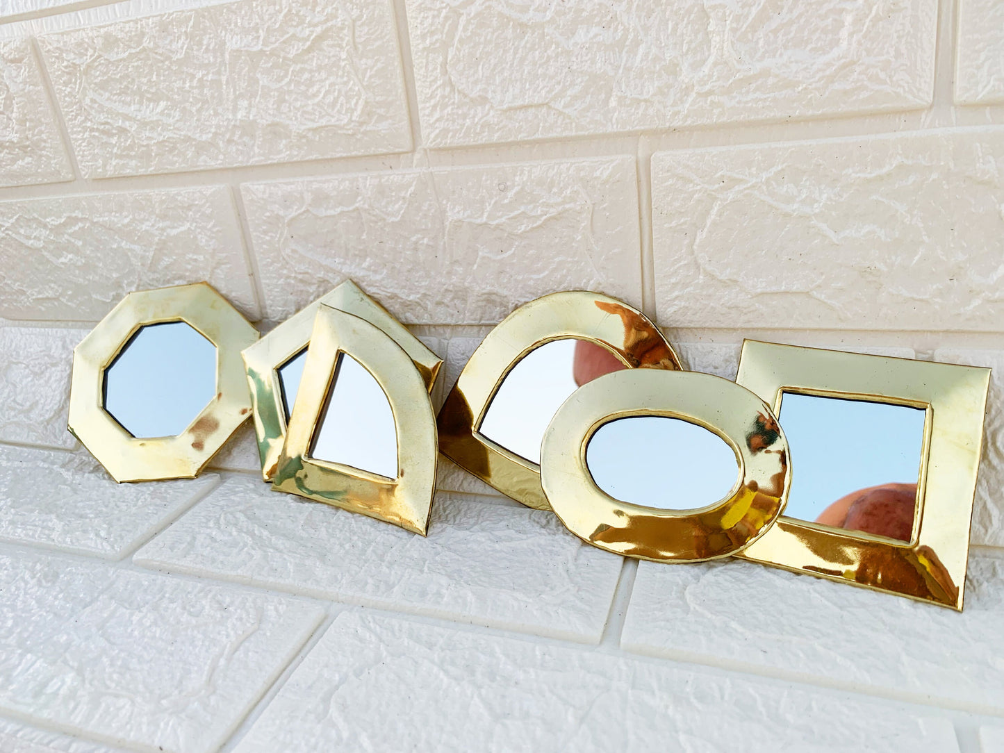 three mirrors sitting on top of a white tile floor