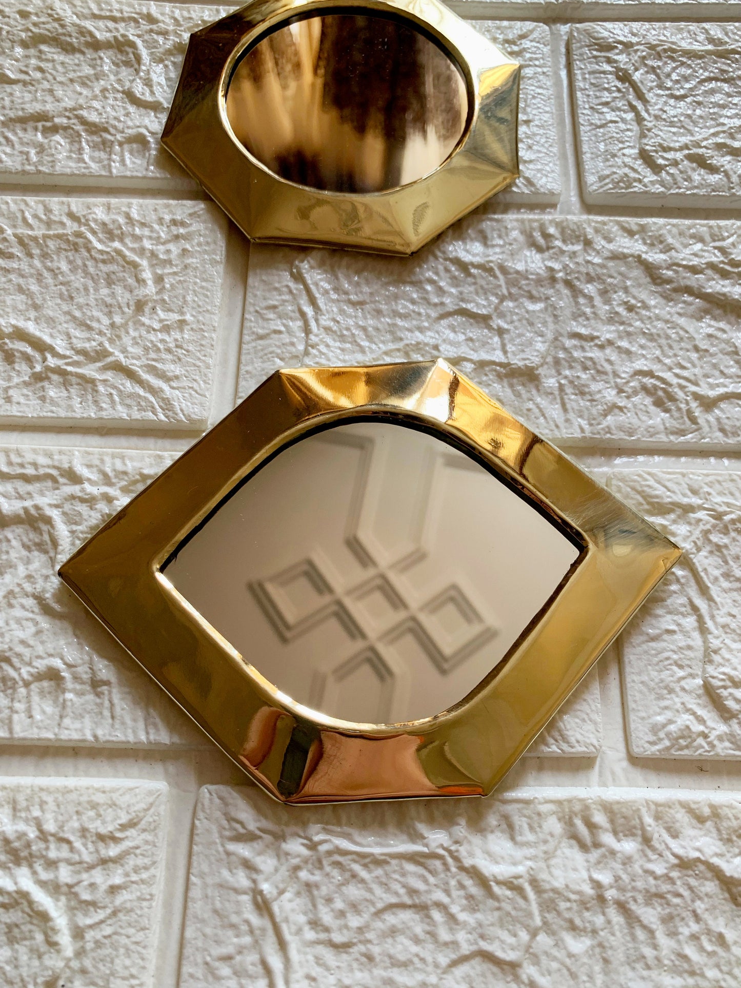 a mirror and a mirror on a white brick wall