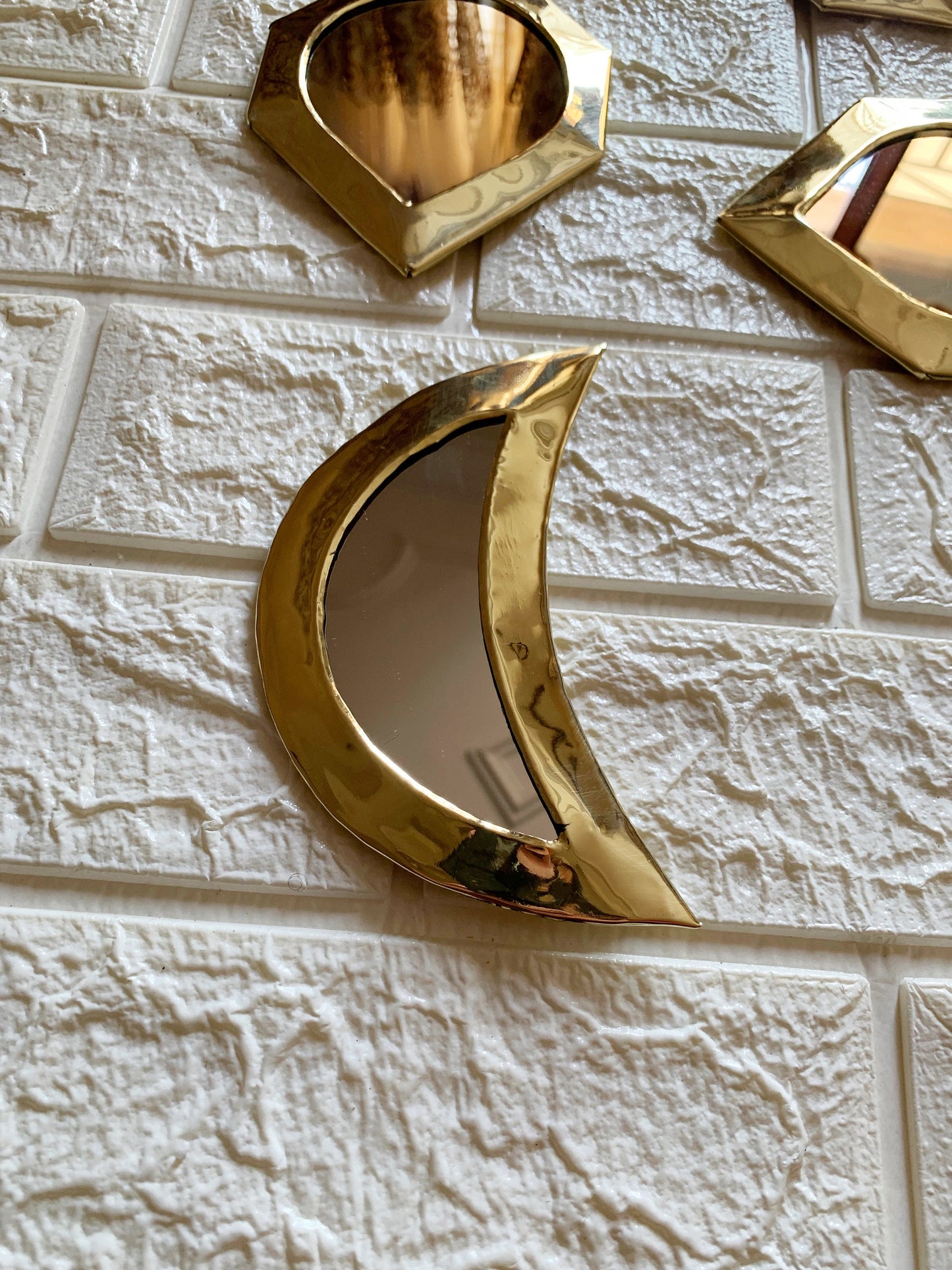 a white brick wall with three mirrors on it