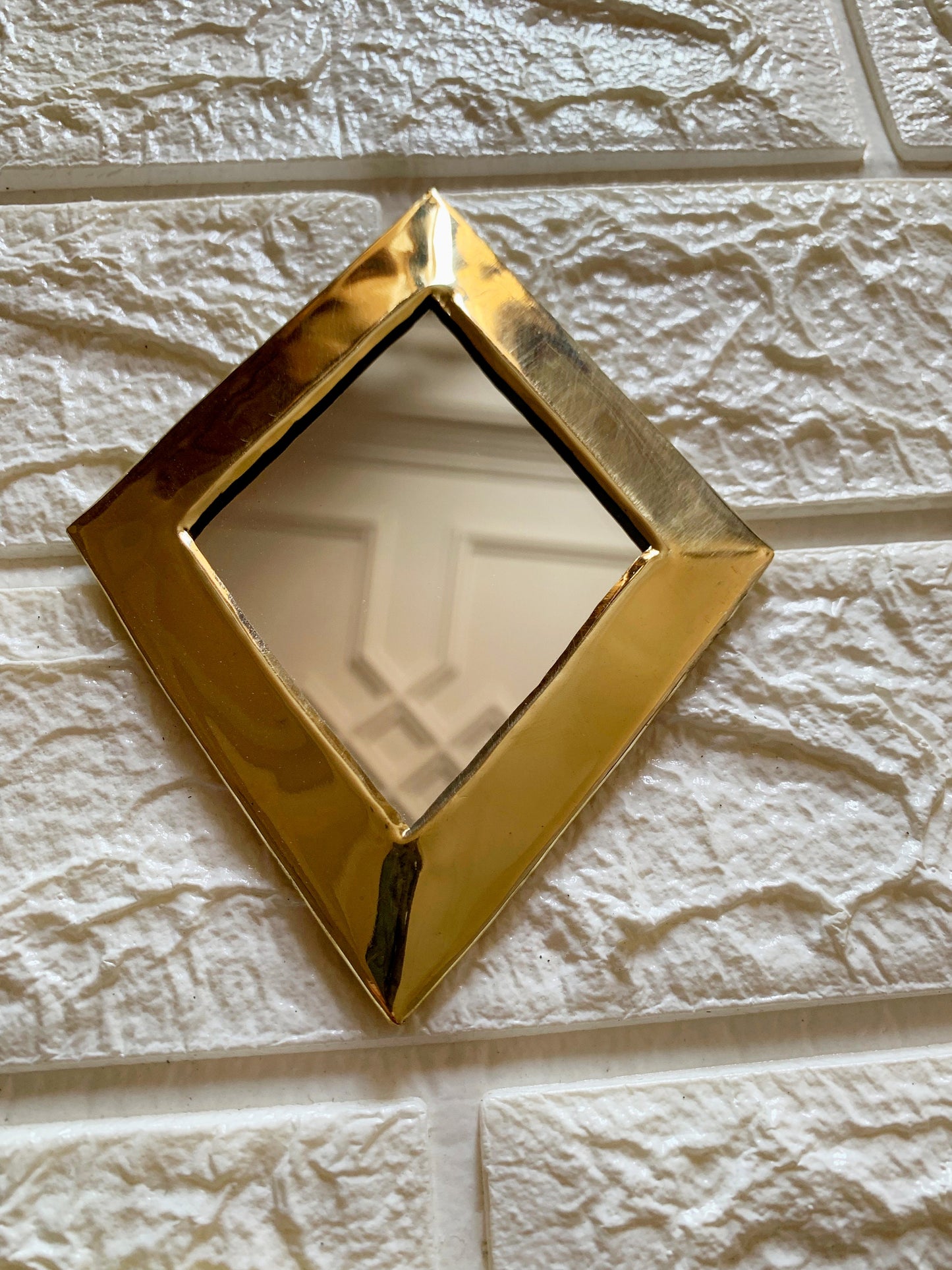 a square shaped mirror mounted on a wall