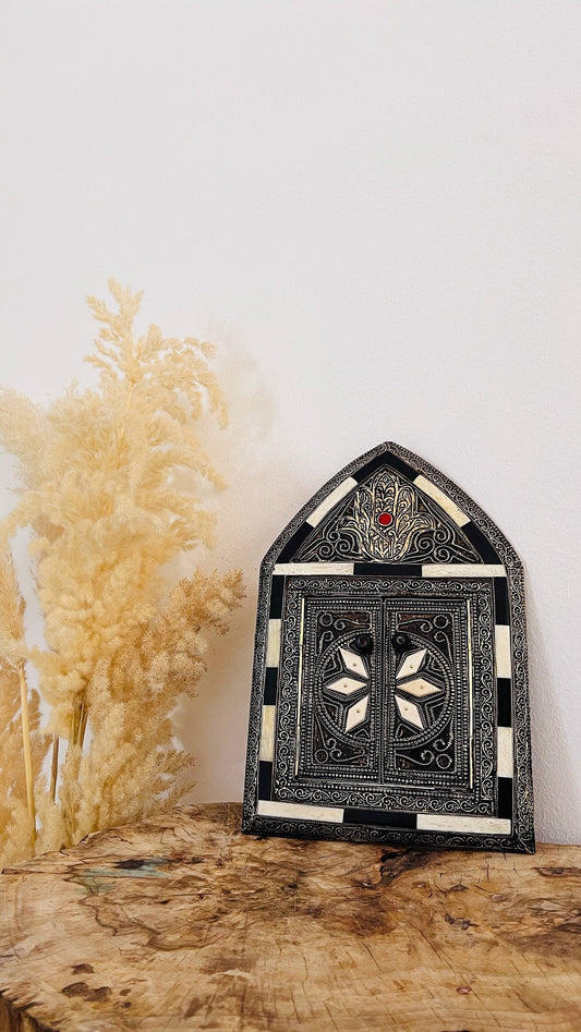 a wooden table with a vase and a decorative mirror on top of it