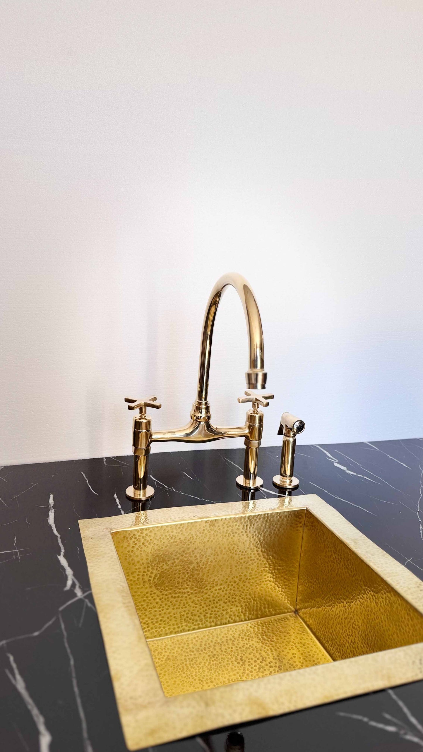 unlacquered brass kitchen faucet with brass sink in kitchen