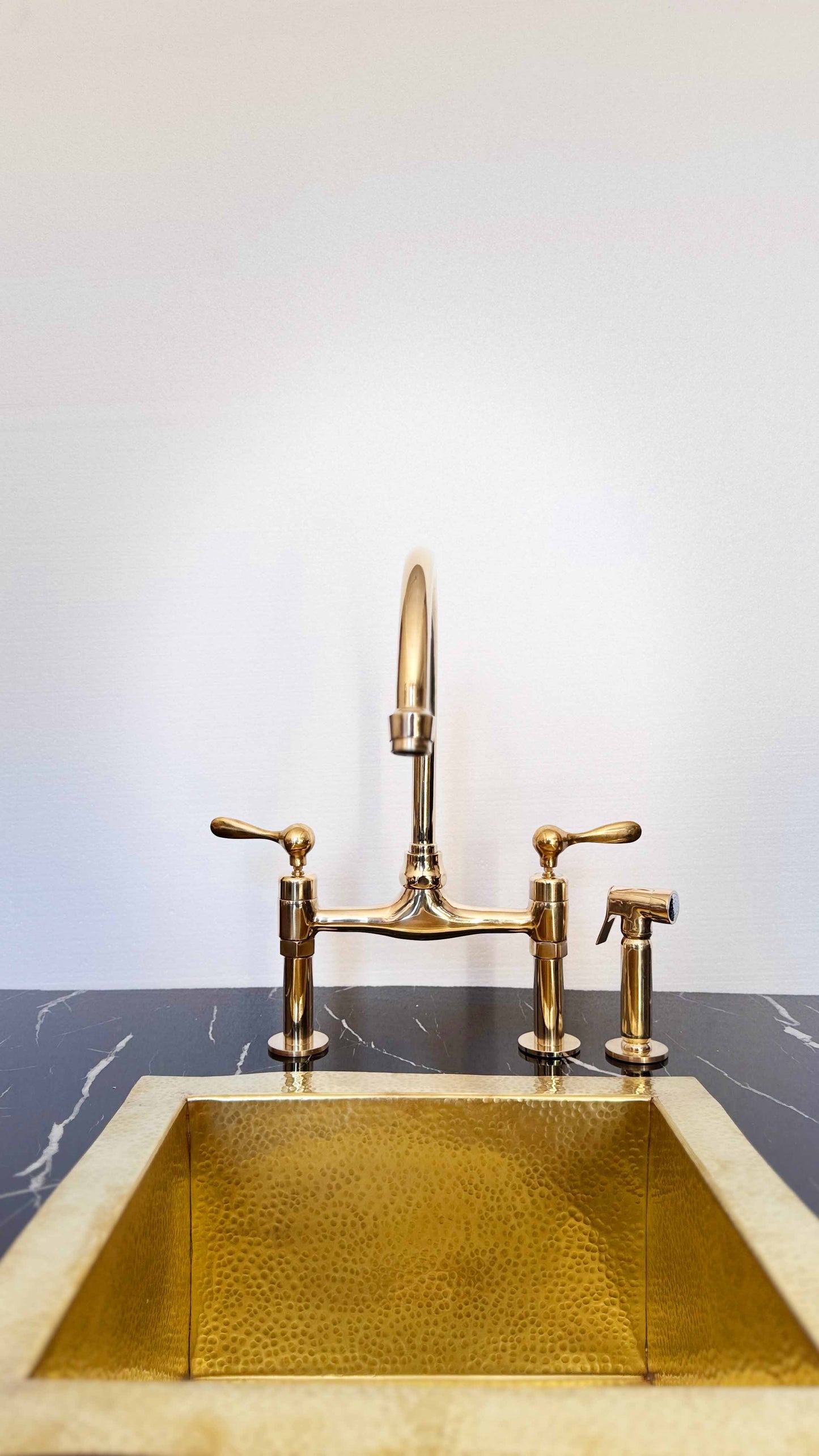 Vintage Unlacquered Brass Bridge faucet with brass sink in kitchen