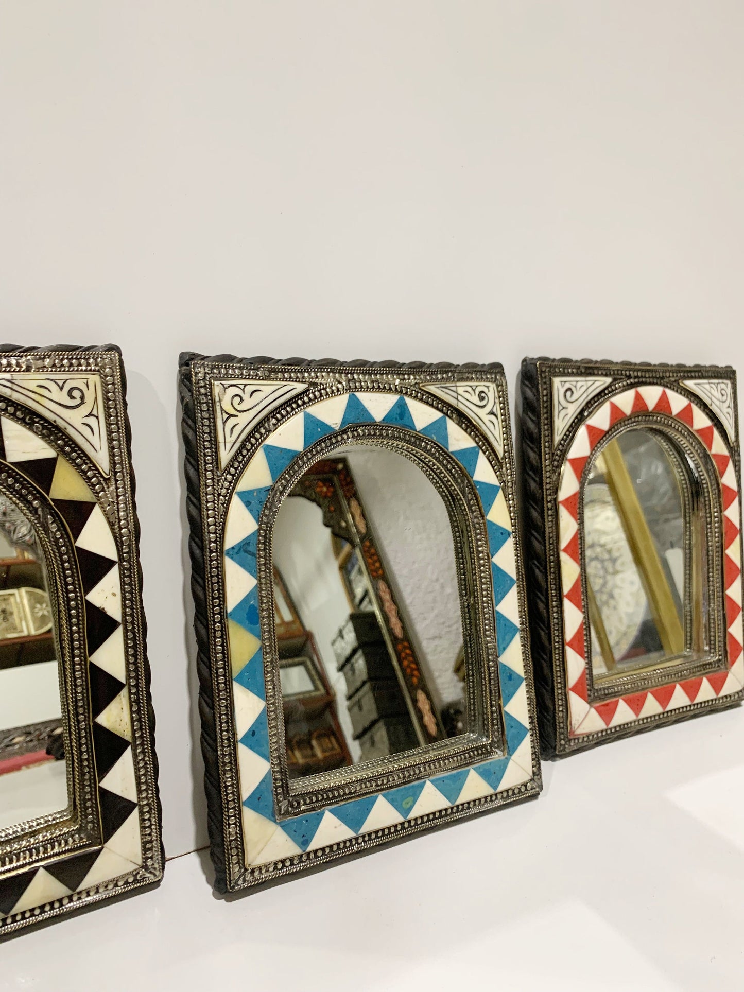 three decorative mirrors are hanging on a wall