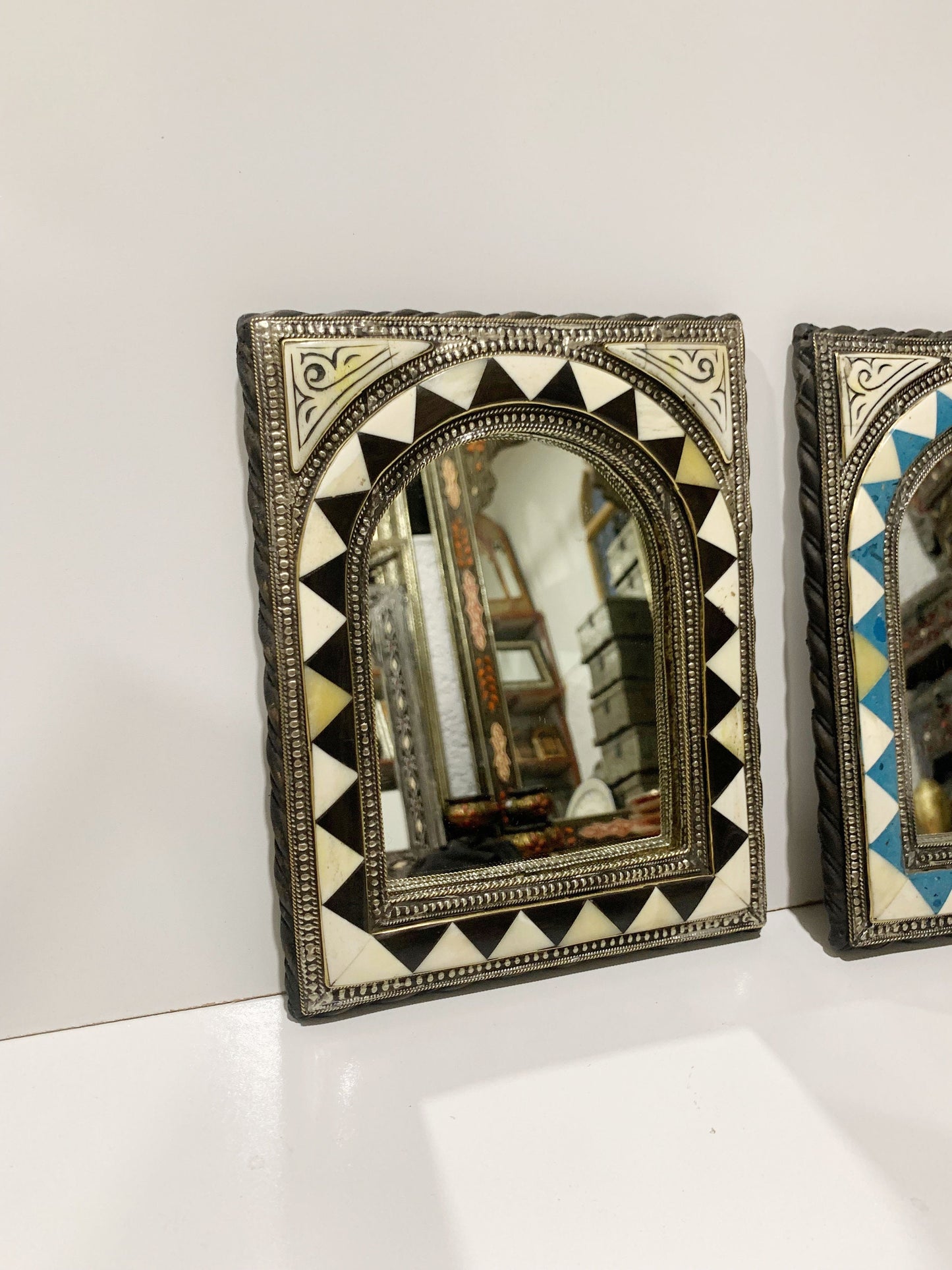 a couple of mirrors sitting on top of a white counter
