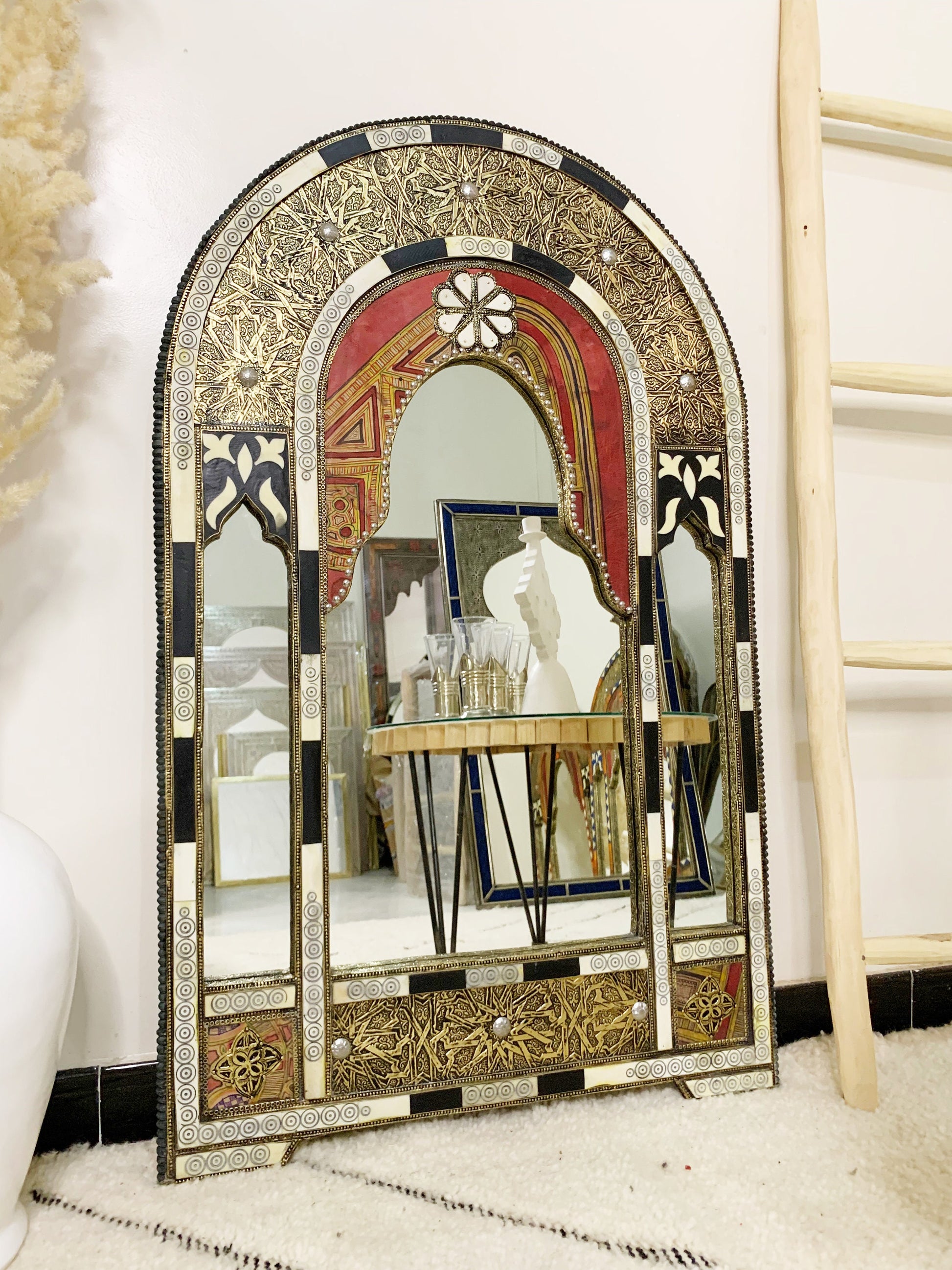 a mirror sitting on top of a table next to a ladder