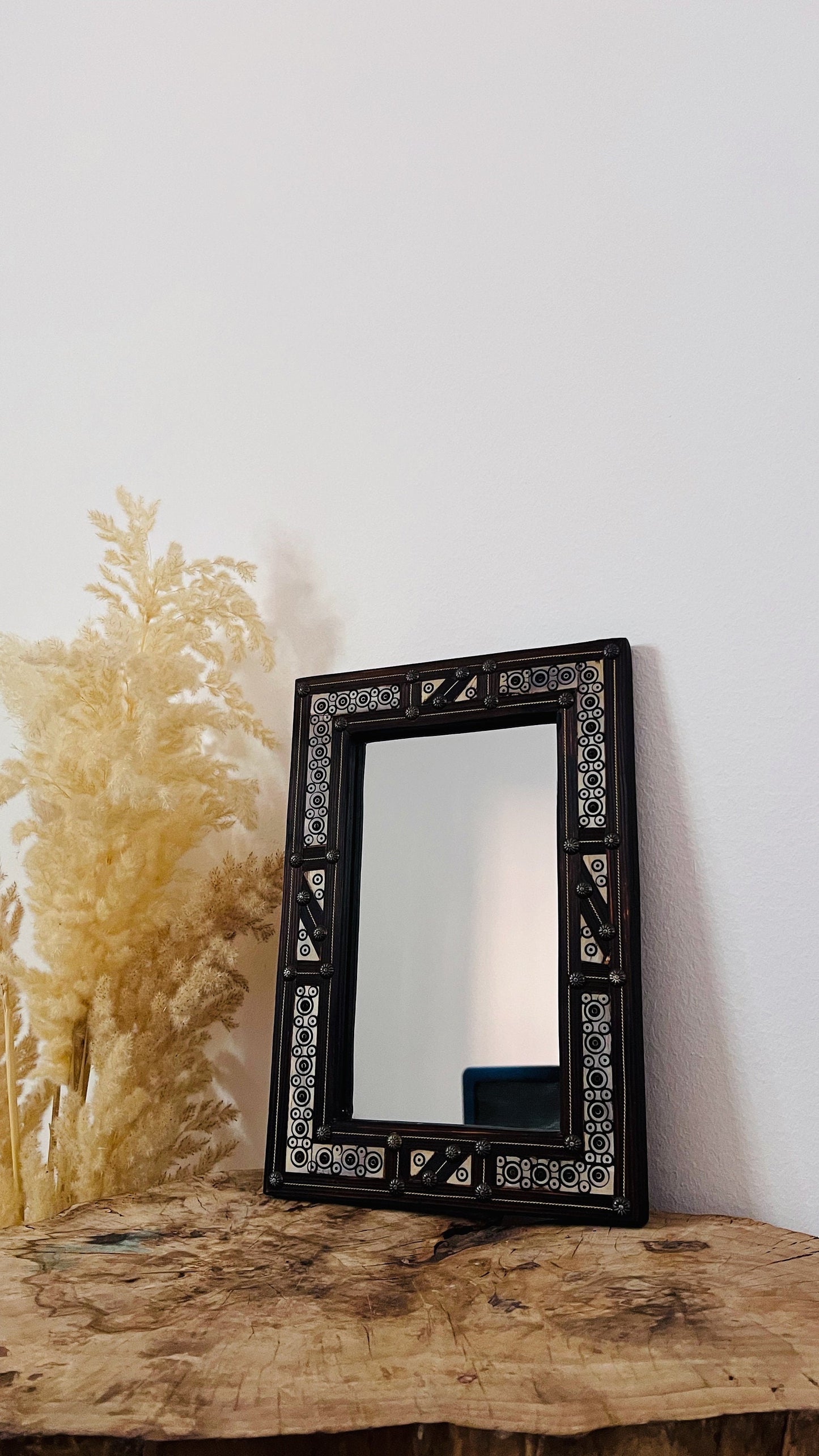 a mirror sitting on top of a wooden table