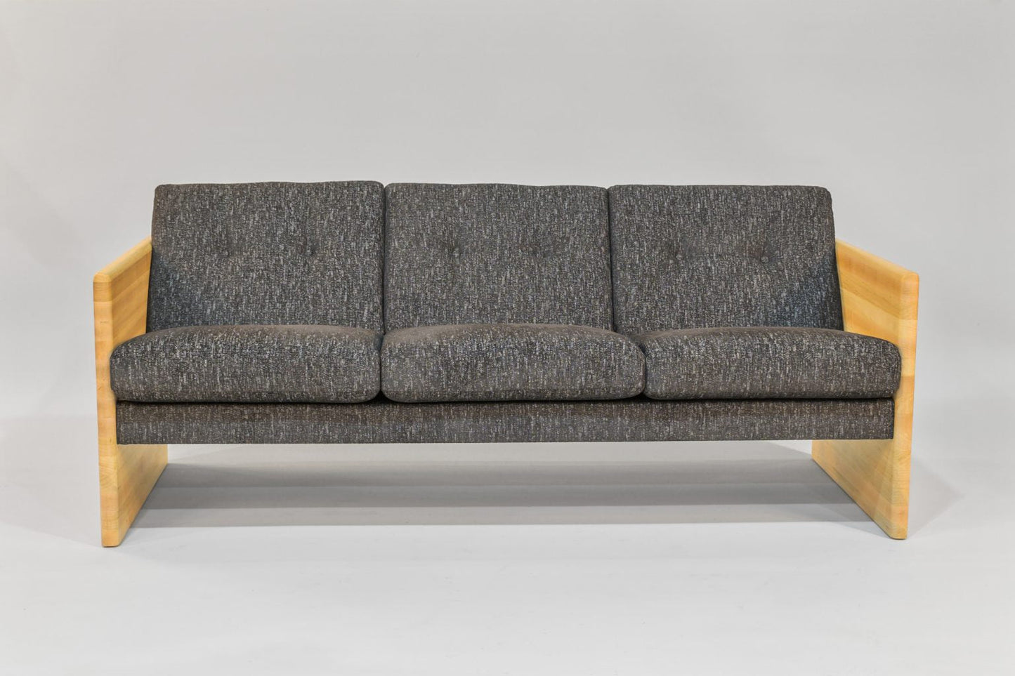 Gray sofa with wooden frame on a gray background