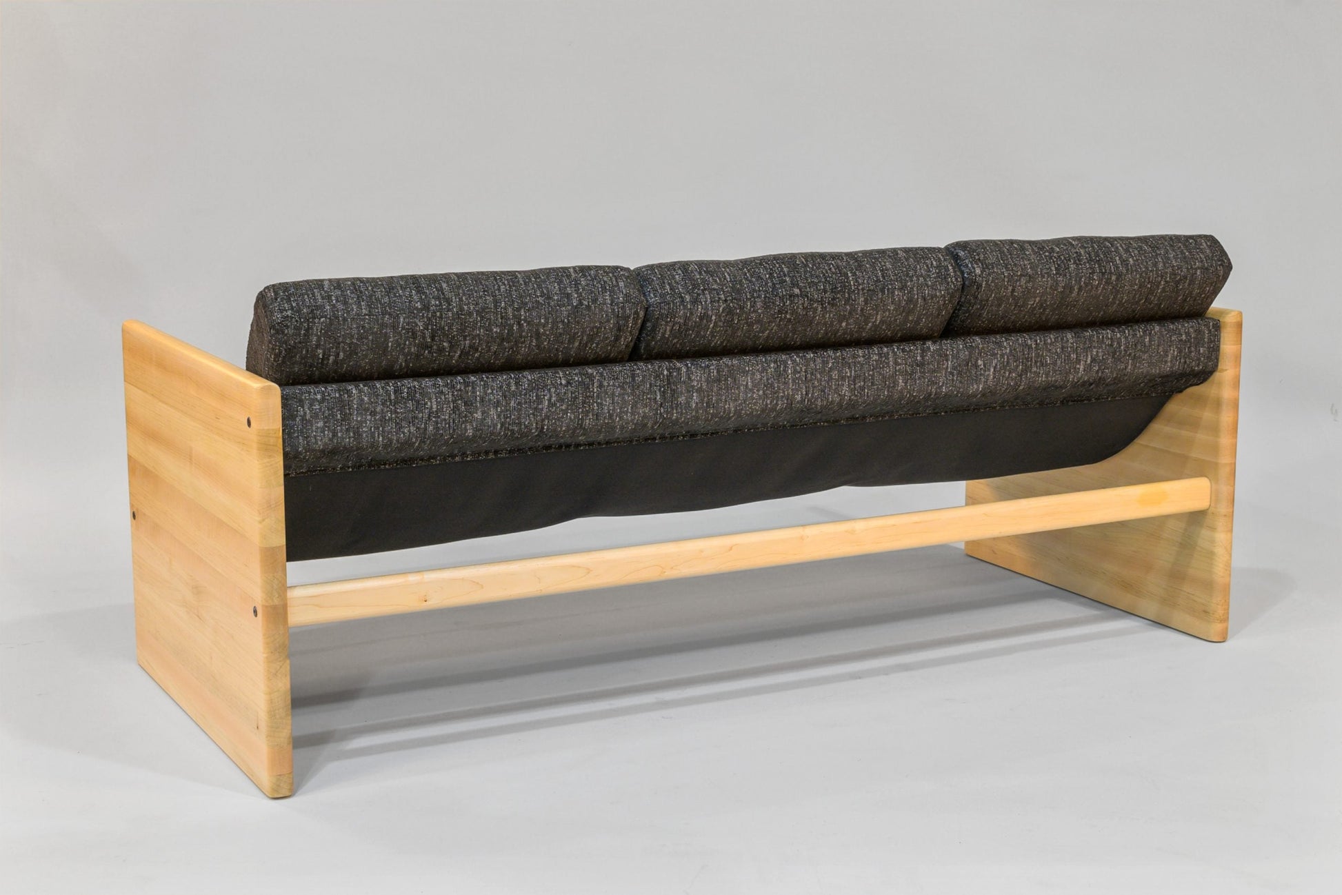 Sofa with wooden frame and gray cushions on a plain background