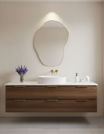 Organic pebble-shaped brass mirror above modern bathroom vanity