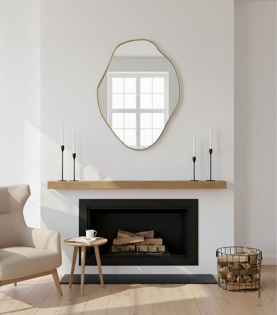 Freeform brass accent mirror above fireplace with modern organic styling