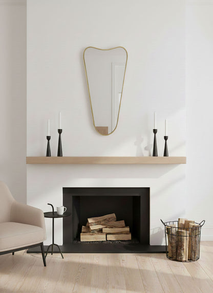 Soft Cone brass mirror styled above a modern fireplace with minimalist decor