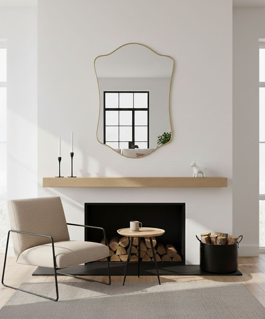 Wavy shield brass mirror above modern fireplace