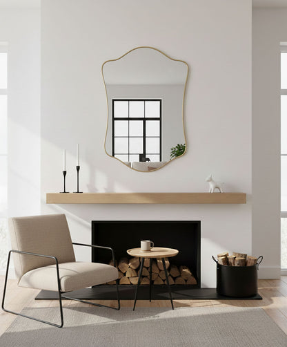 Wavy shield brass mirror above modern fireplace