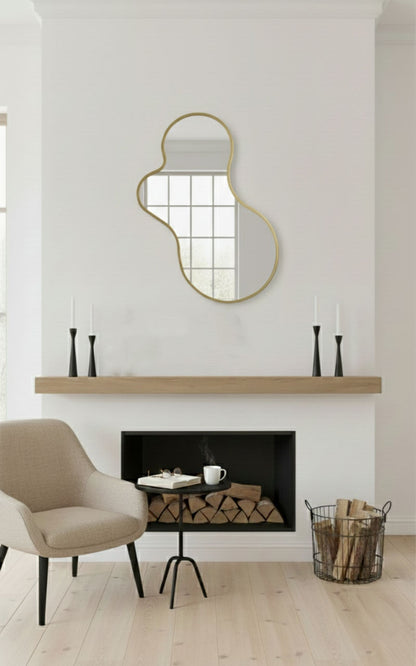 Amoeba brass wall mirror above a modern fireplace mantel
