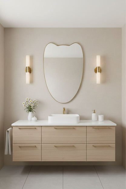 Bathroom vanity styled with Double-Petal Crest brass mirror and modern wall sconces