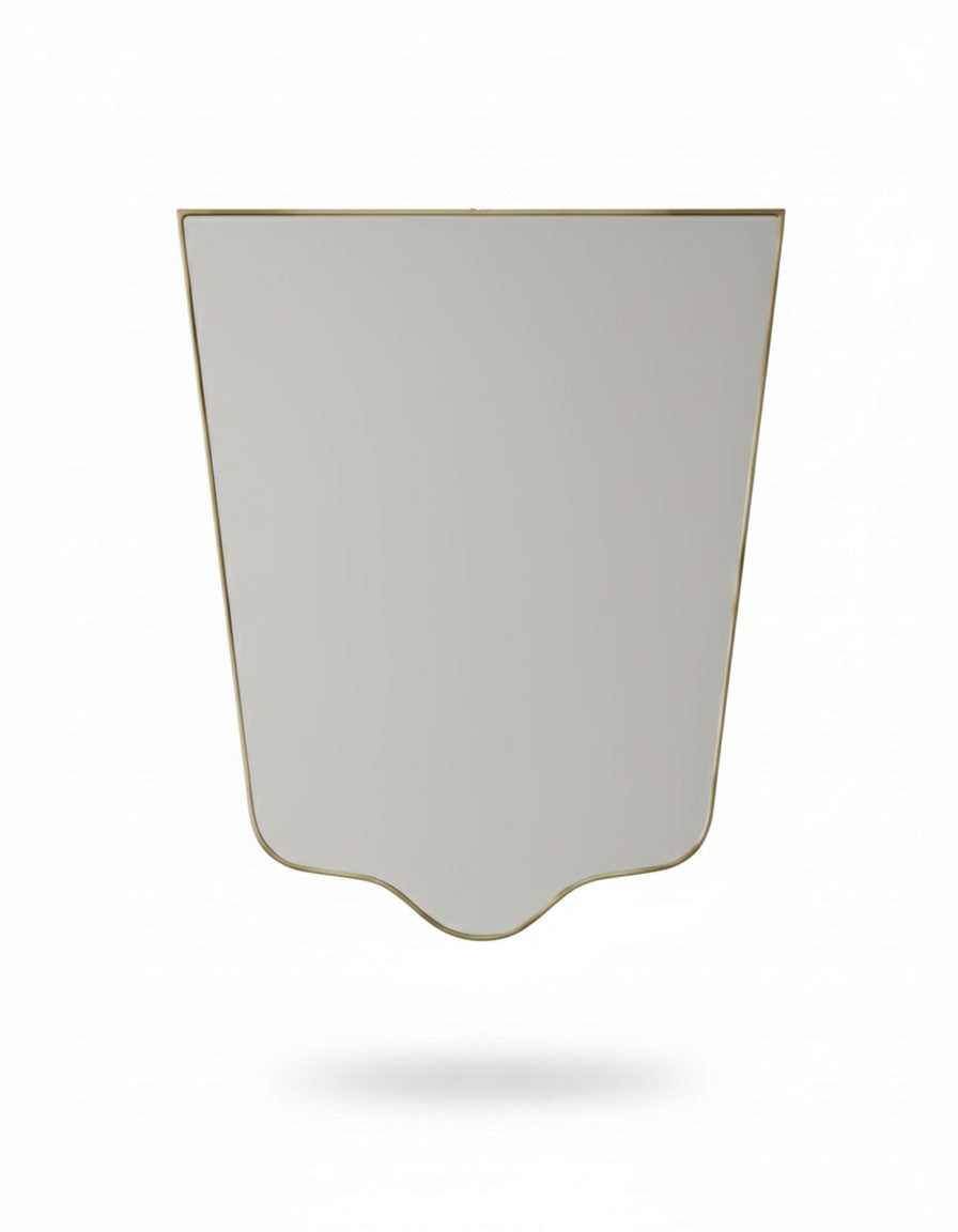 Minimal crest-edge brass mirror with tapered silhouette on white background