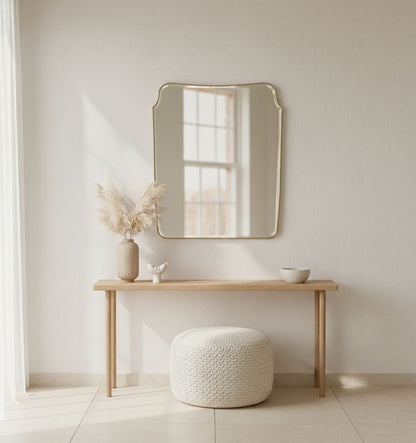 Rounded crest rectangle brass mirror styled above a minimalist console table