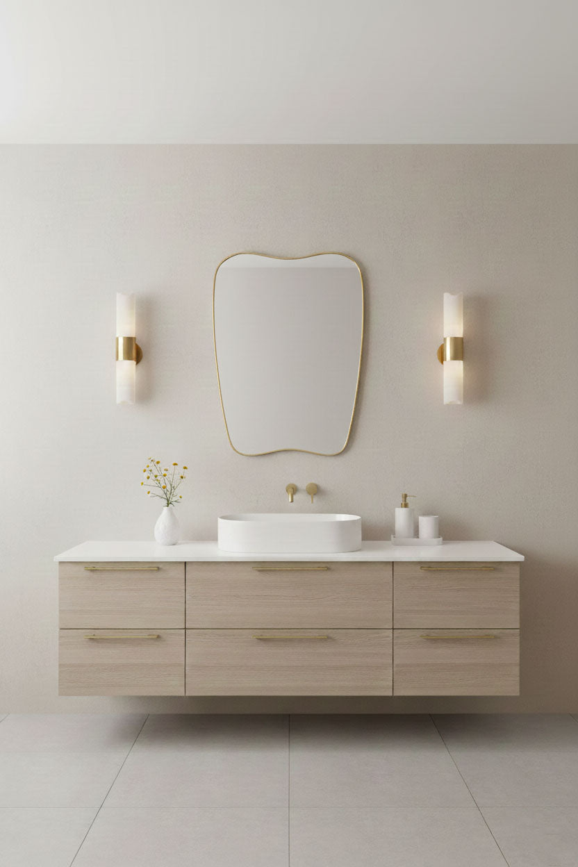  Soft-crest brass mirror above a modern floating bathroom vanity