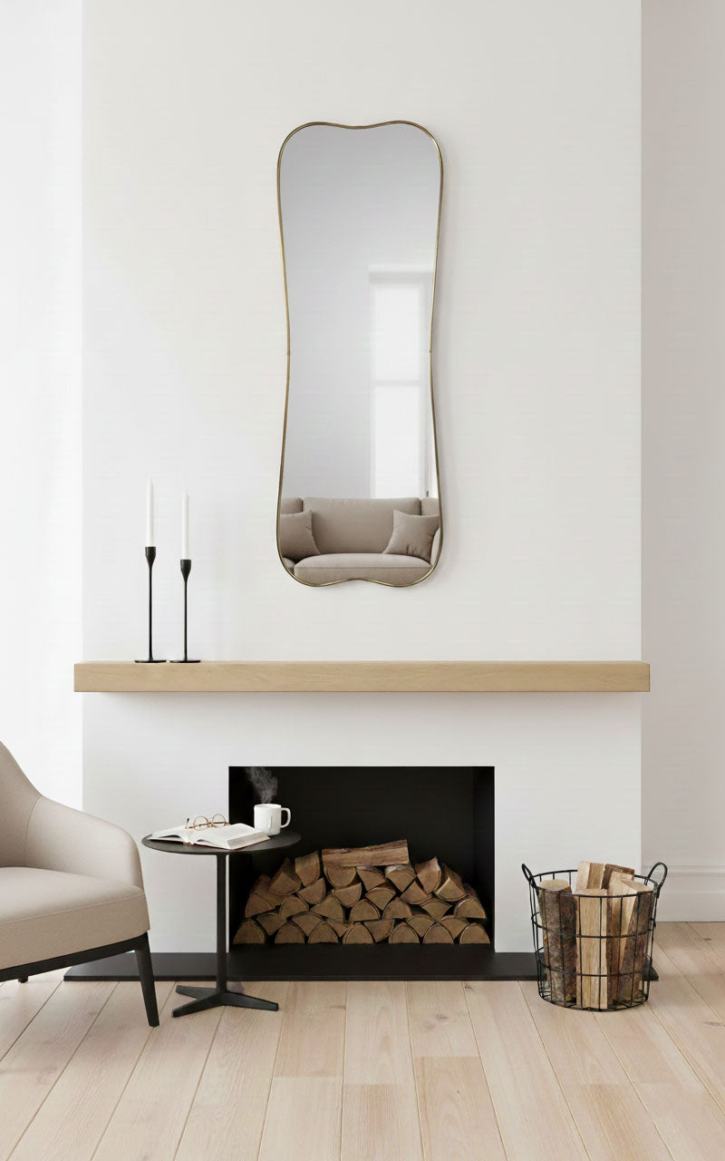 Belle Curve rectangle brass mirror above modern fireplace