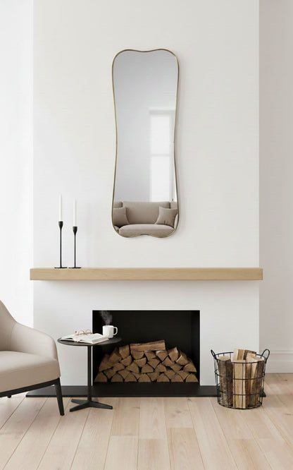 Belle Curve rectangle brass mirror above modern fireplace