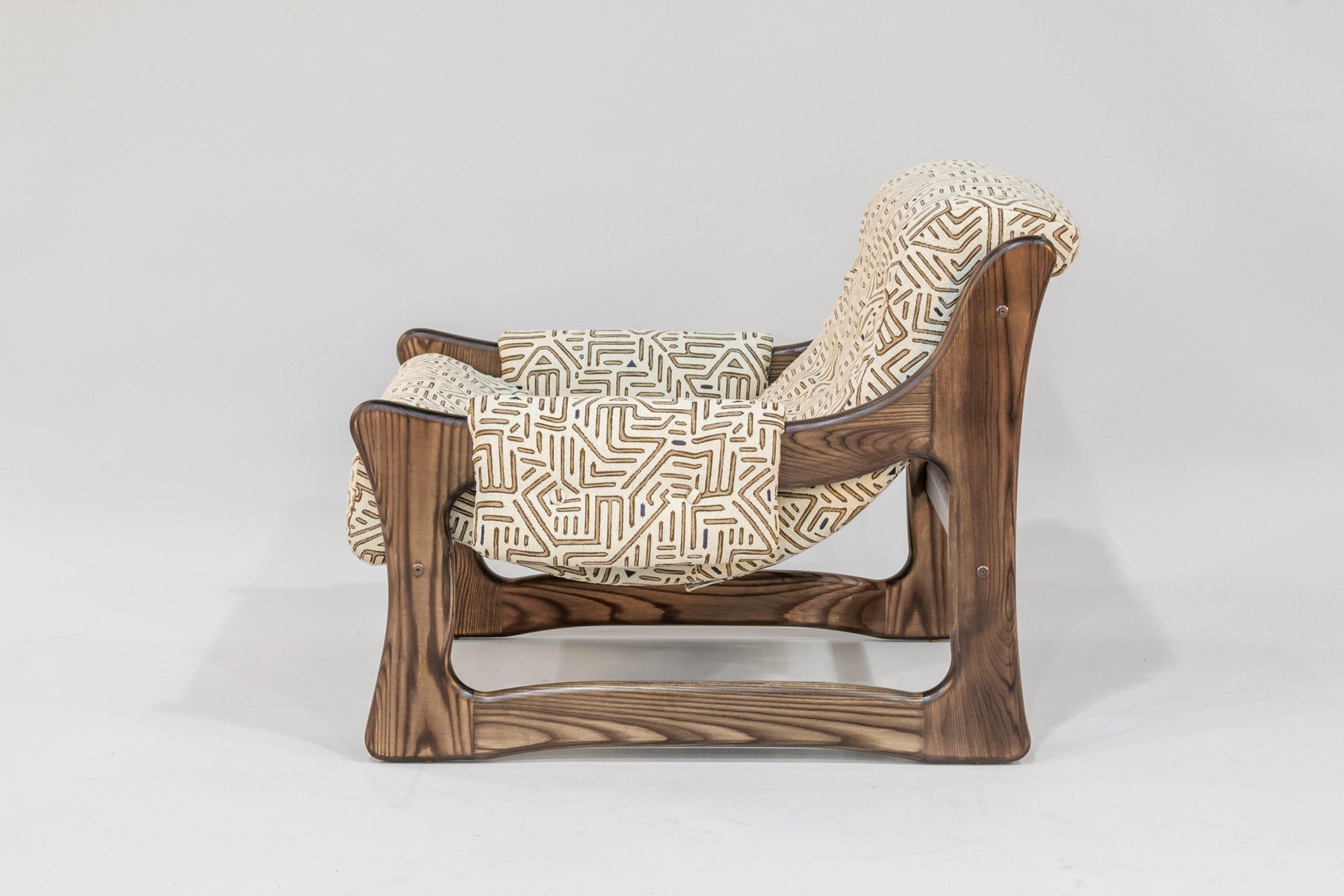 Wooden chair with patterned cushion on a white background