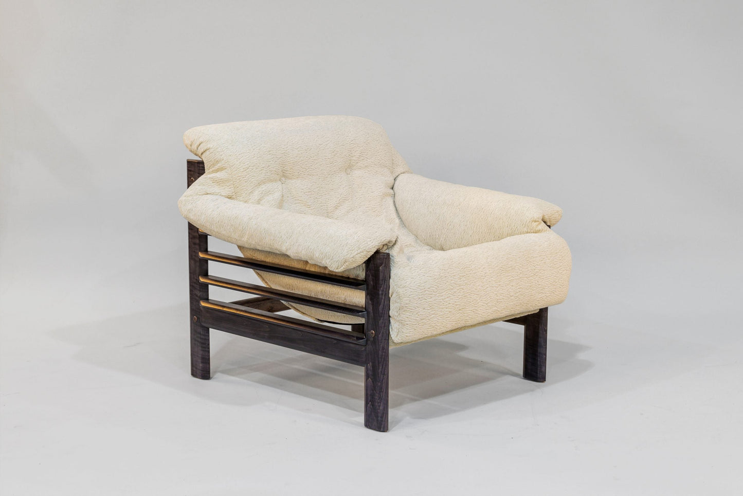 Beige armchair with dark wooden frame on a gray background