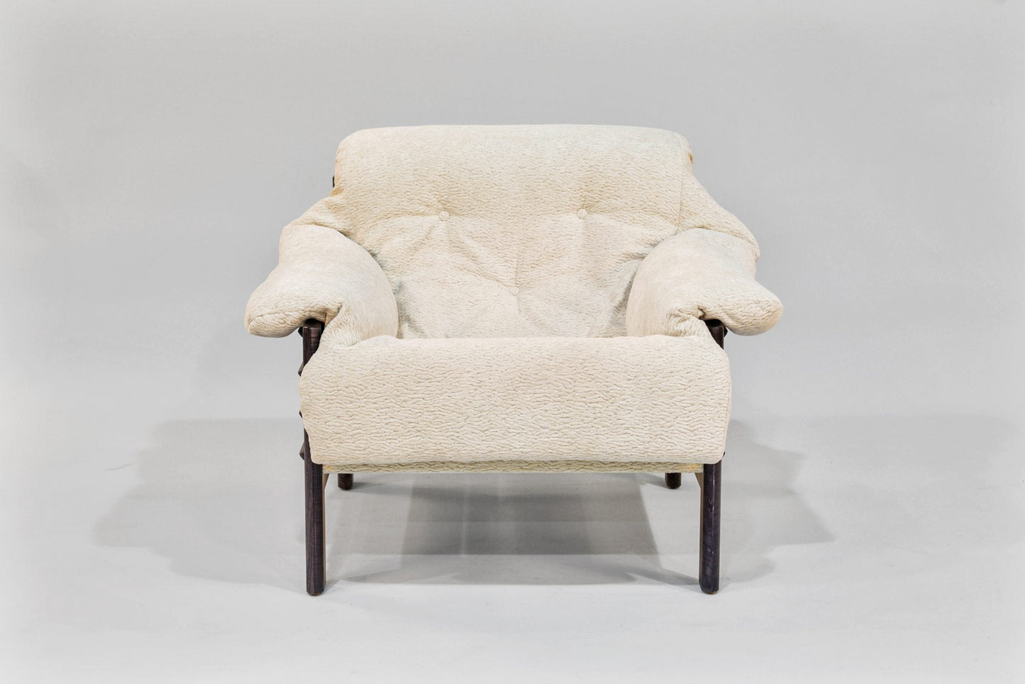 Cream-colored armchair with wooden legs on a light gray background