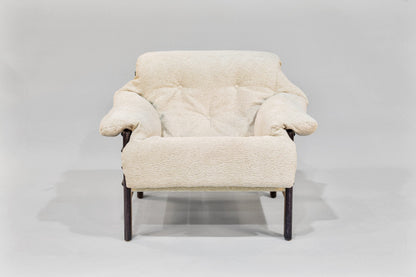 Cream-colored armchair with wooden legs on a light gray background