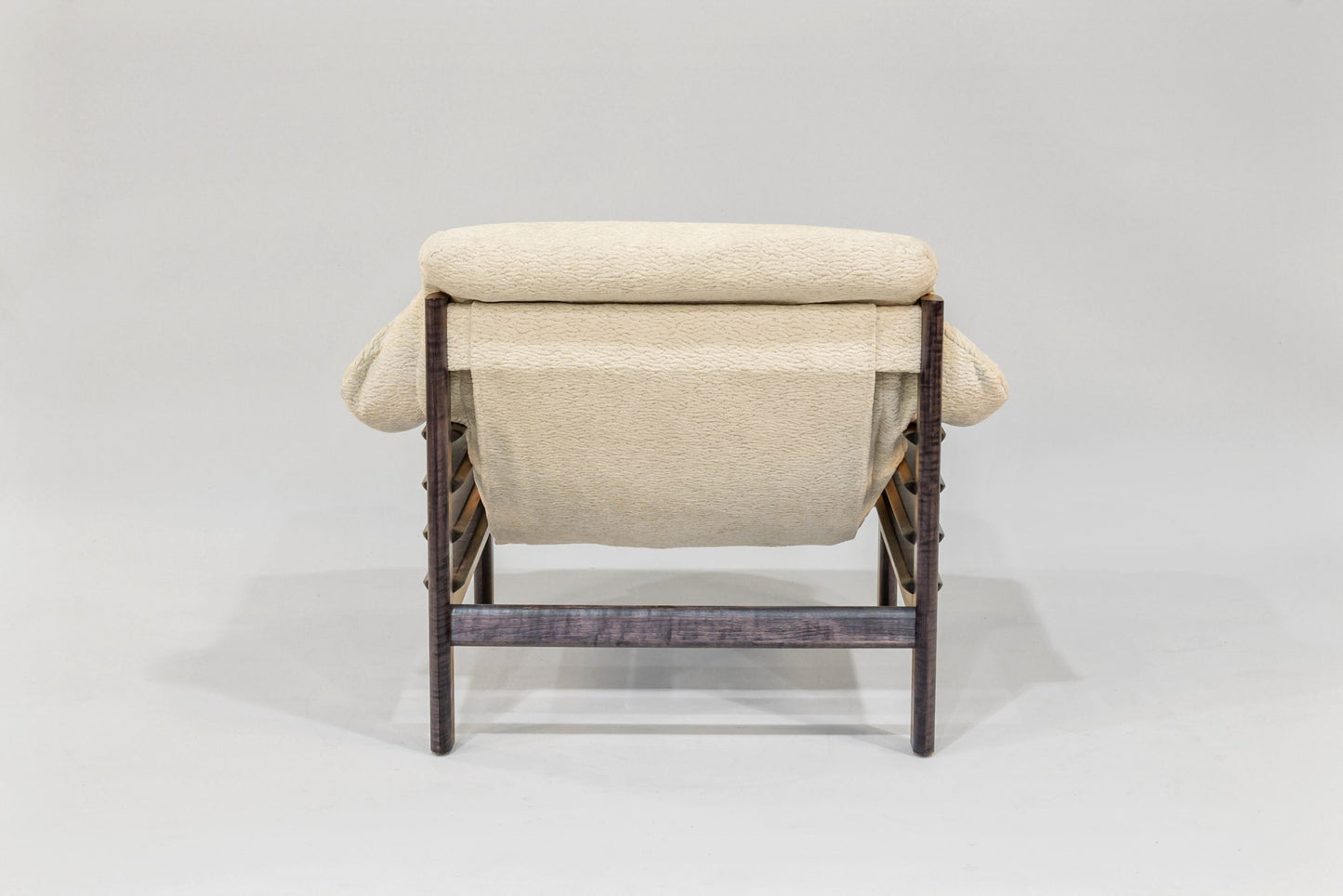 Beige lounge chair with wicker frame on a white background