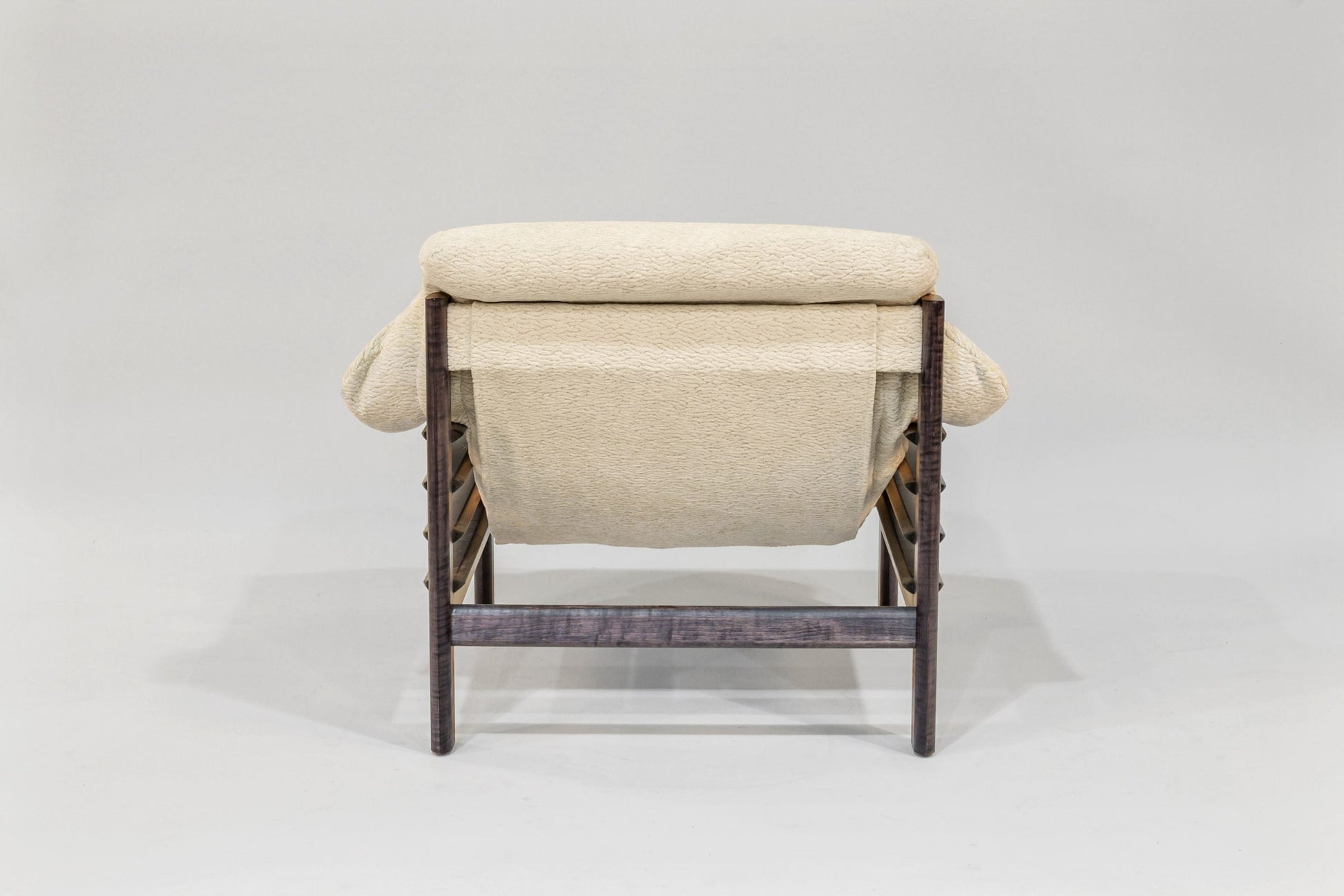 Beige lounge chair with wicker frame on a white background