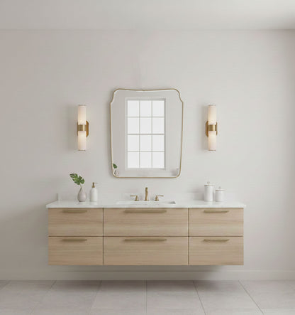 Rounded crest rectangle brass mirror mounted above a modern bathroom vanity