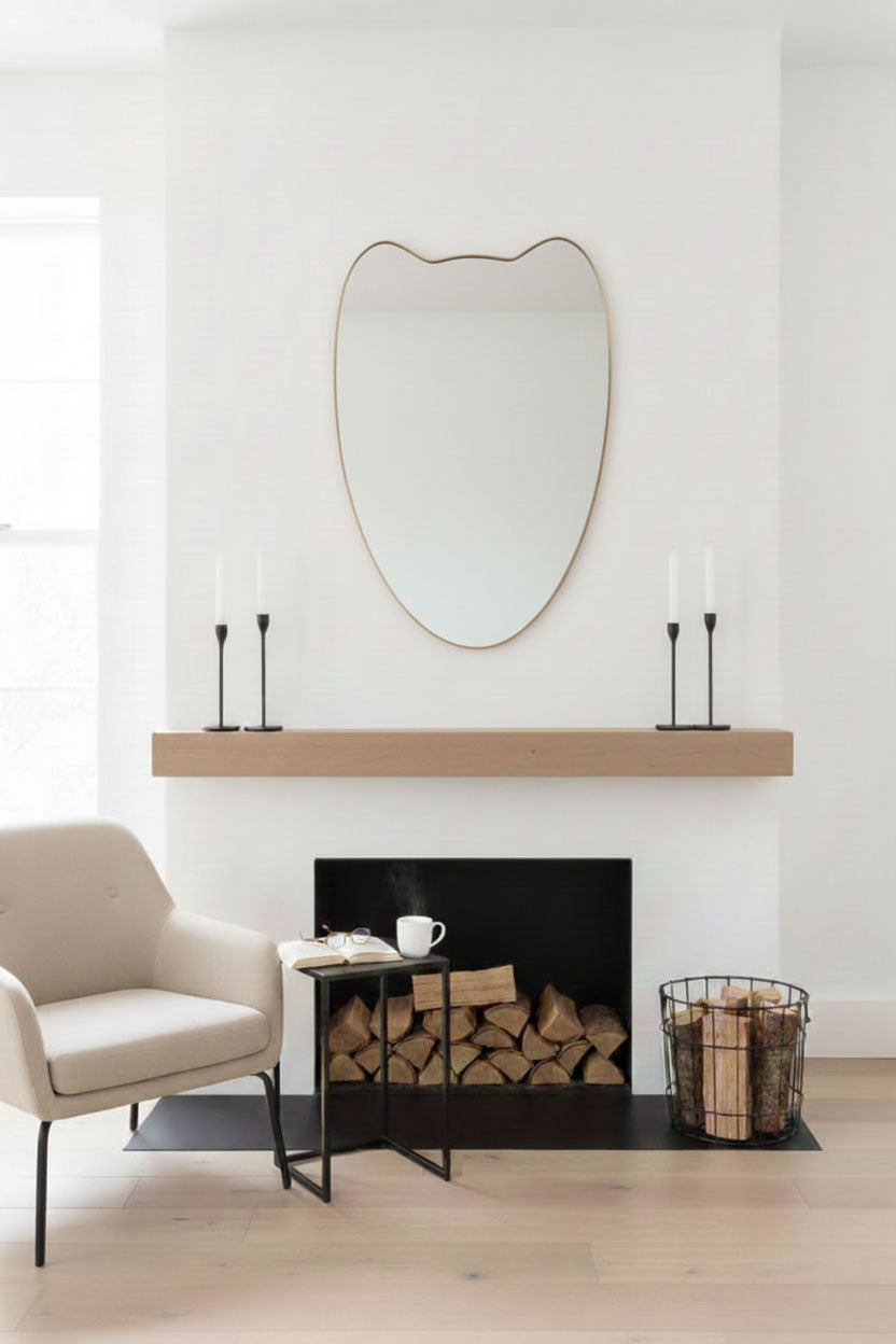 Double-Petal Crest mirror above fireplace with organic brass frame