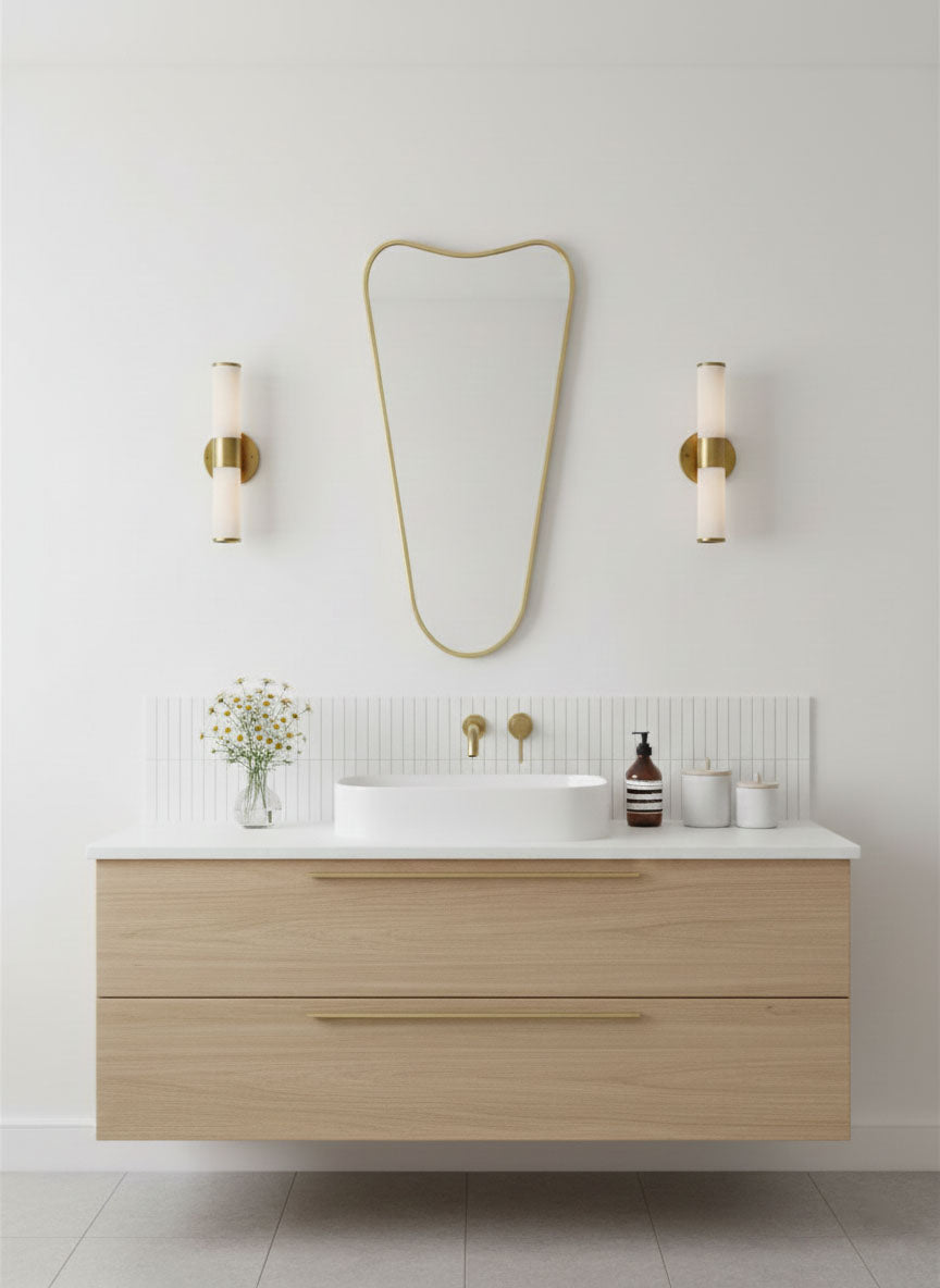 Soft Cone brass vanity mirror mounted above a floating bathroom sink
