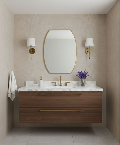 Contoured rectangle brass mirror in a minimalist double sink bathroom