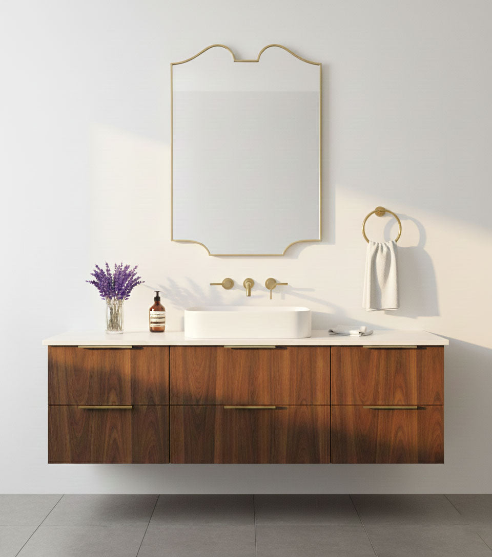 Scalloped twin-curve brass mirror in warm neutral bathroom