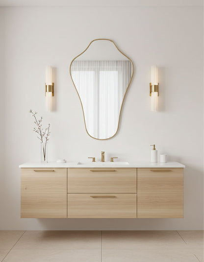 Sculpted crest mirror above modern bathroom vanity with light wood cabinetry