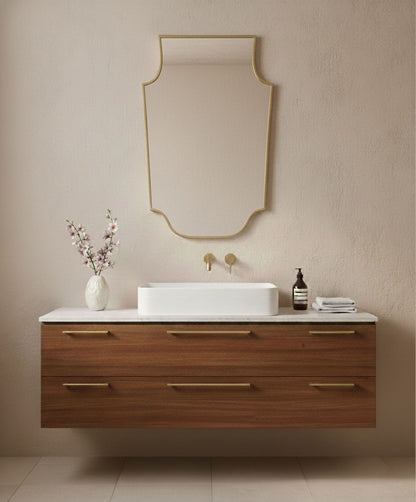 Crest-shaped brass mirror above wooden vanity