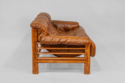 Brown leather sofa with wooden frame on a white background