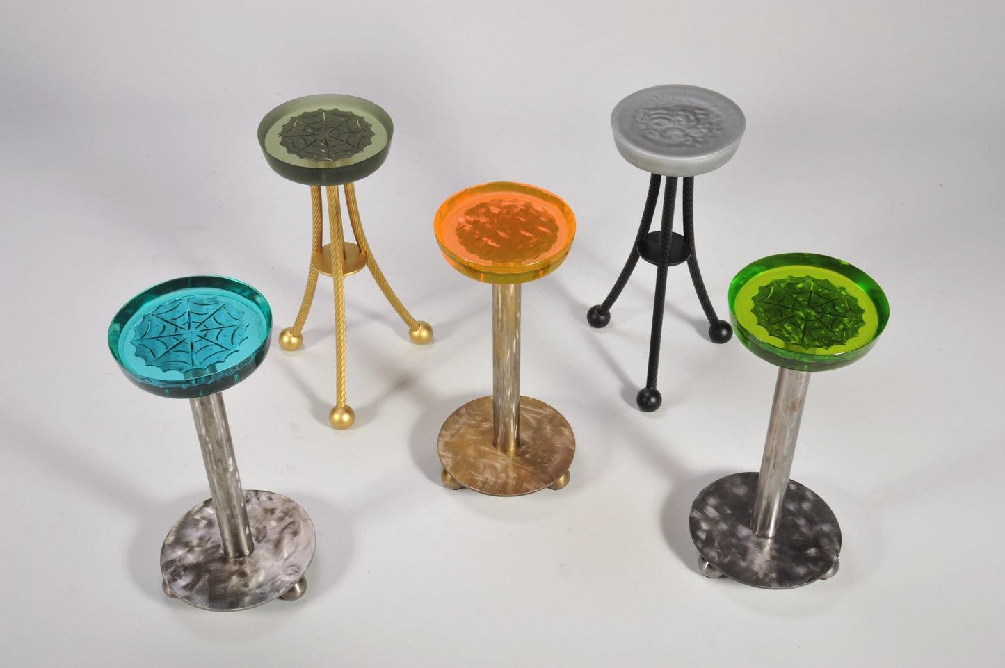Set of five colorful stools with unique designs on a white background