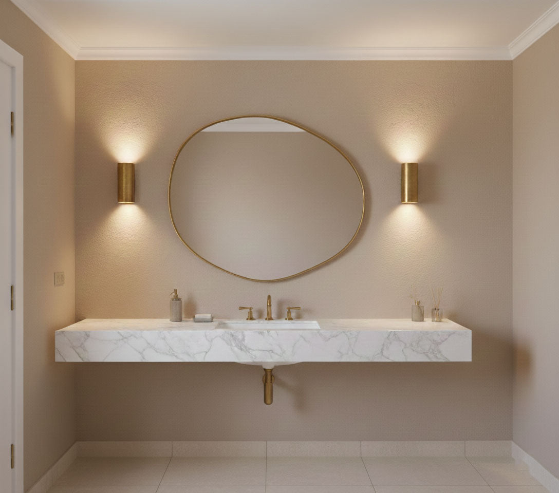 Organic raw edge brass mirror mounted above a marble bathroom sink