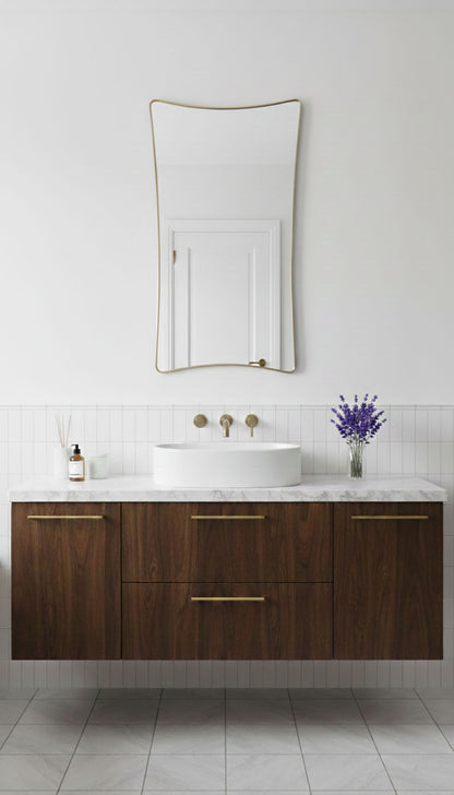 S-curve brass vanity mirror mounted above modern bathroom sink