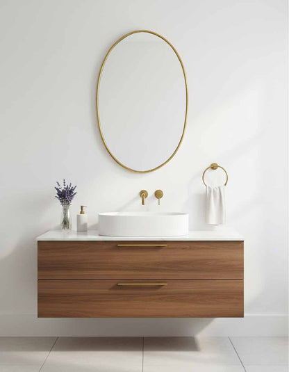 Oval brass wall mirror above floating vanity