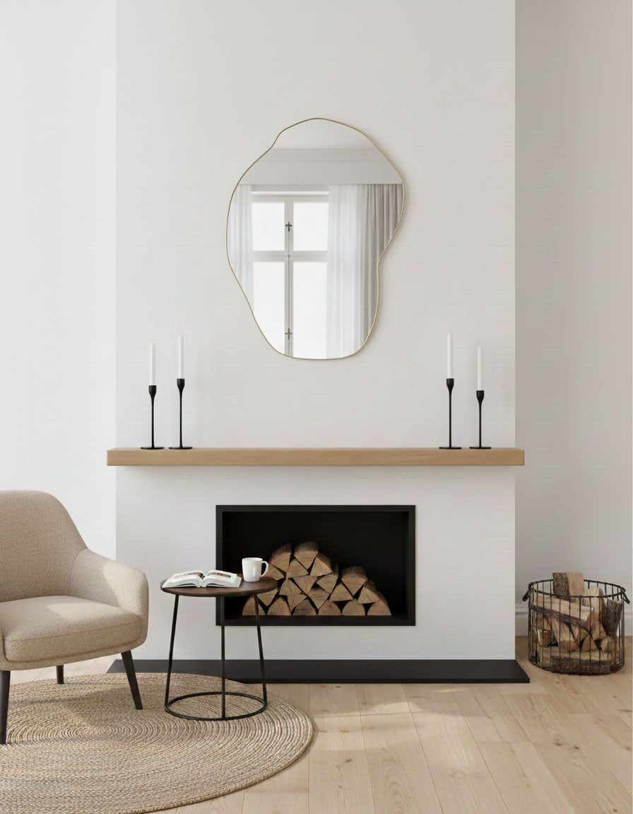 Asymmetrical brass wall mirror above fireplace mantel