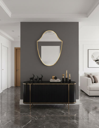 Modern interior with a black console table, gold-framed mirror, and gray sofa.