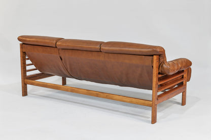 Brown leather sofa with wooden frame on a white background