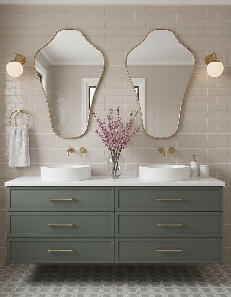 Pair of sculpted crest mirrors above double bathroom vanity with brass fixtures